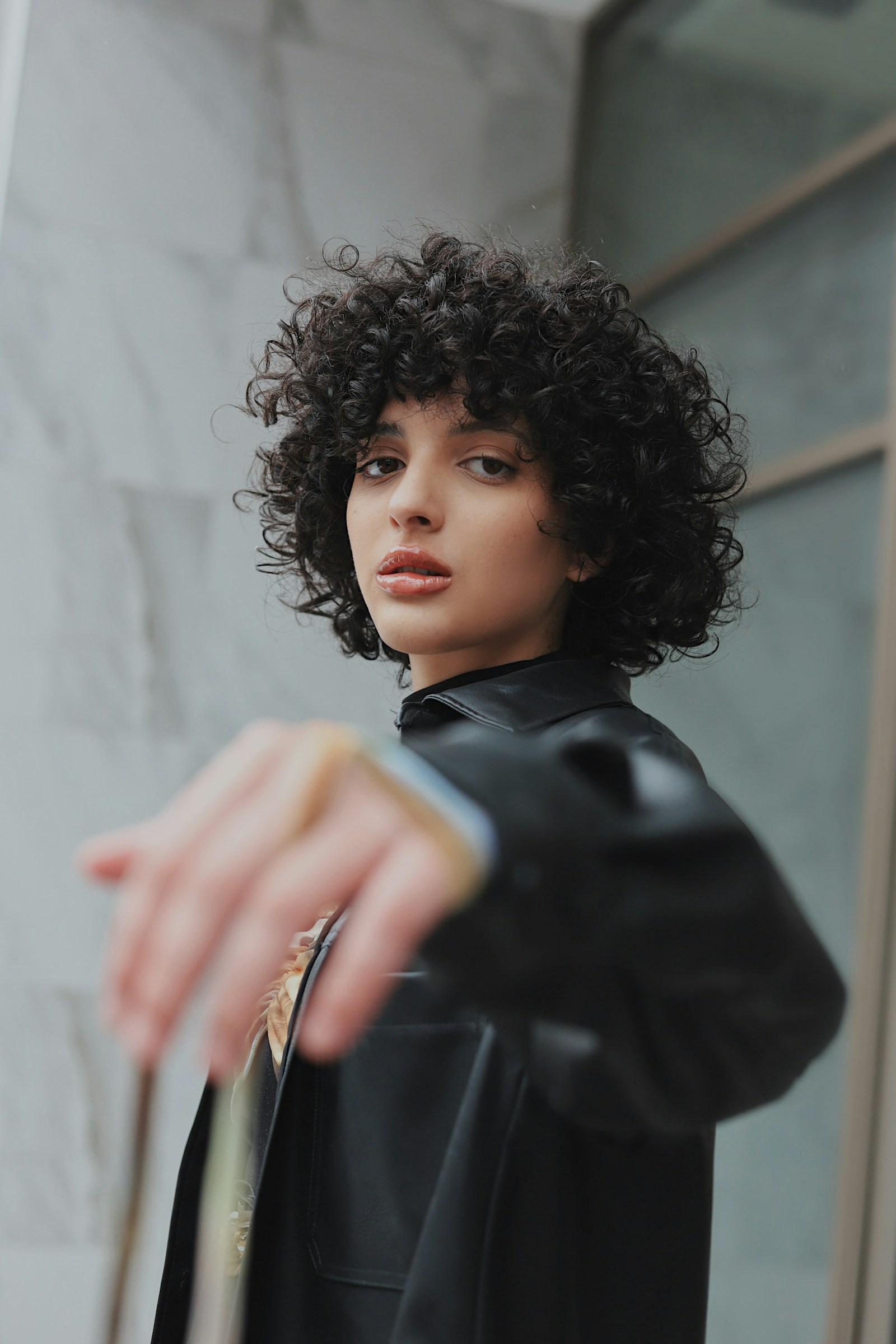 Editorial portrait showing a softly shaped curly bob
